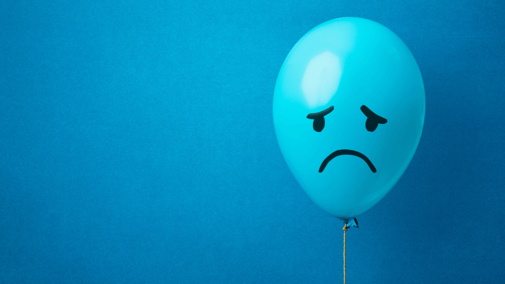 悲しそうな顔の絵が書いてある水色の風船