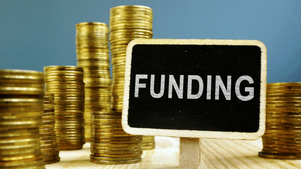 積み上げられたコインとFUNDINGと書かれた札